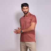 Man wearing a Sierra polo shirt and beige pants against a light gray background