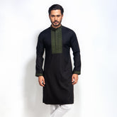 Man wearing a black panjabi with green embroidery on a white background