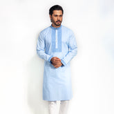 Man wearing a light blue kurta with white pants on a white background