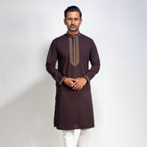 Man wearing a brown Coffee with white pants on a light gray background