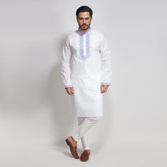 Man wearing a white kurta with embroidery on a light gray background