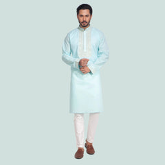 Man wearing a light blue kurta with white pants on a white background