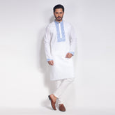 Man wearing a white panjabi with blue embroidery on a white background