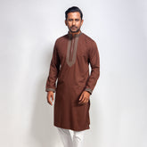 Man wearing a coffee color panjabi with white pants on a light gray background