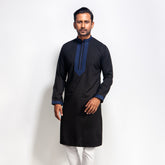 Man wearing a black panjabi with blue embroidery on a white background