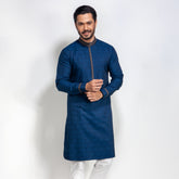 Man wearing a blue panjabi with white pants on a white background