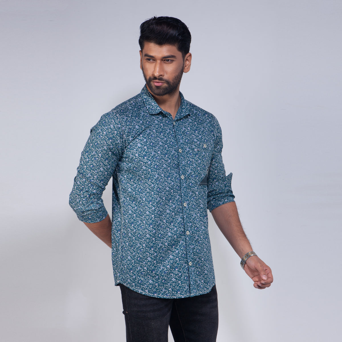 Man wearing a blue patterned shirt against a white background