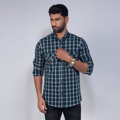 Man wearing a green and gray plaid shirt against a plain background