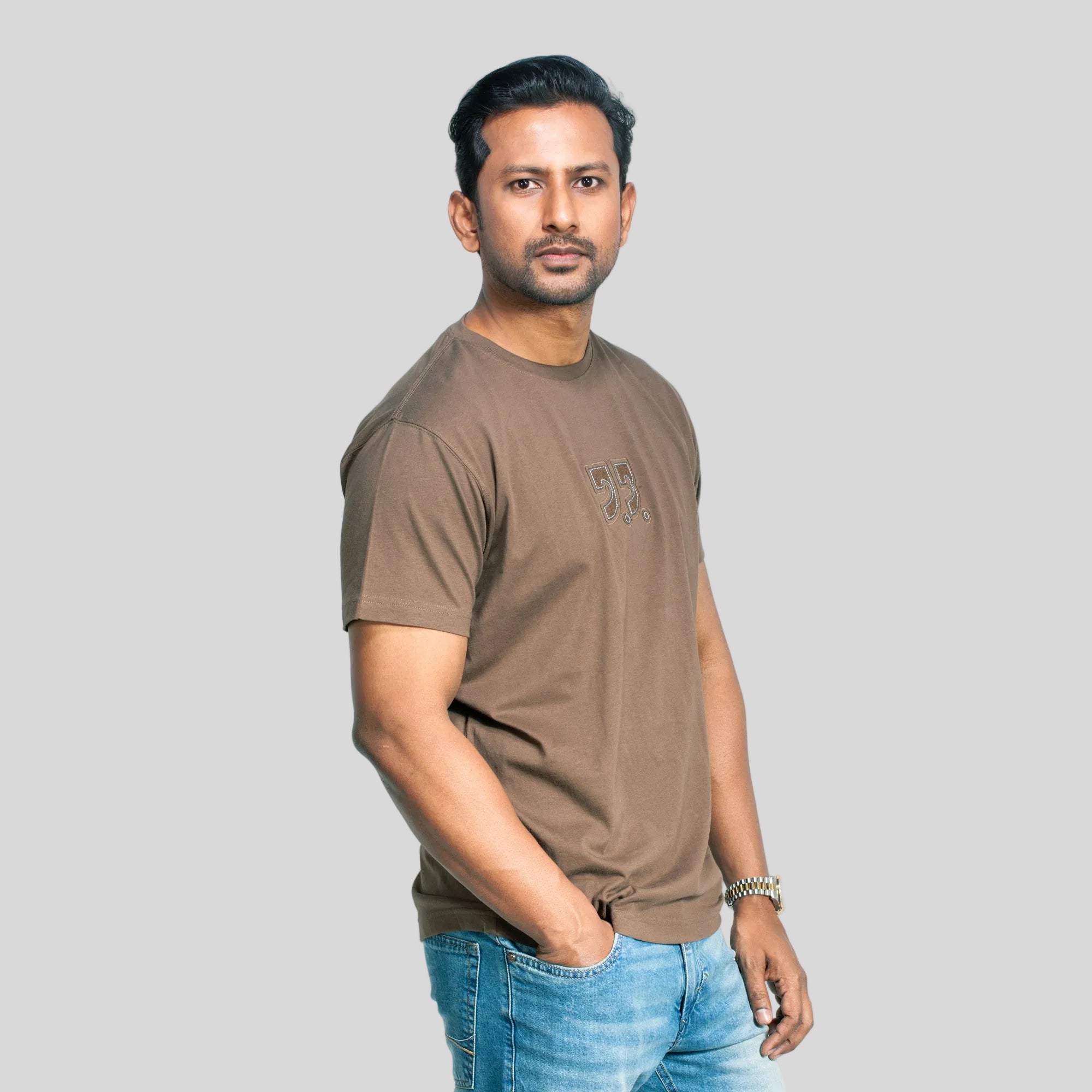 Man wearing a brown t-shirt with a logo on a white background