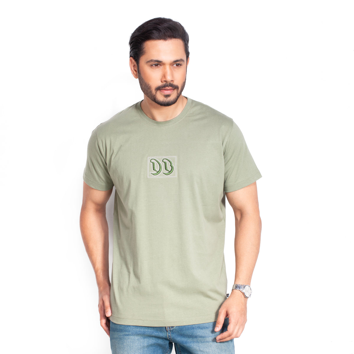 Man wearing a Olive t-shirt with a logo on a gray background