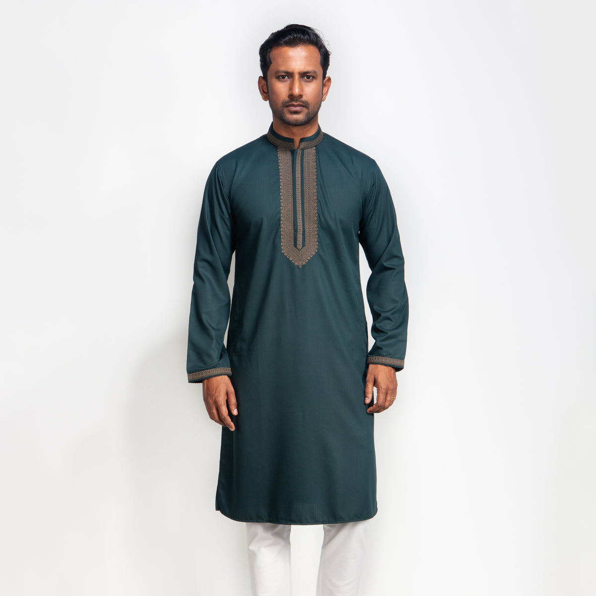 Man wearing a dark green kurta with white pants on a white background