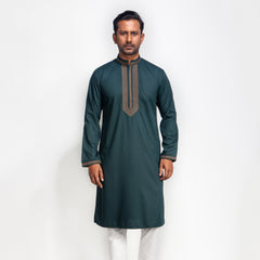 Man wearing a dark green kurta with white pants on a white background
