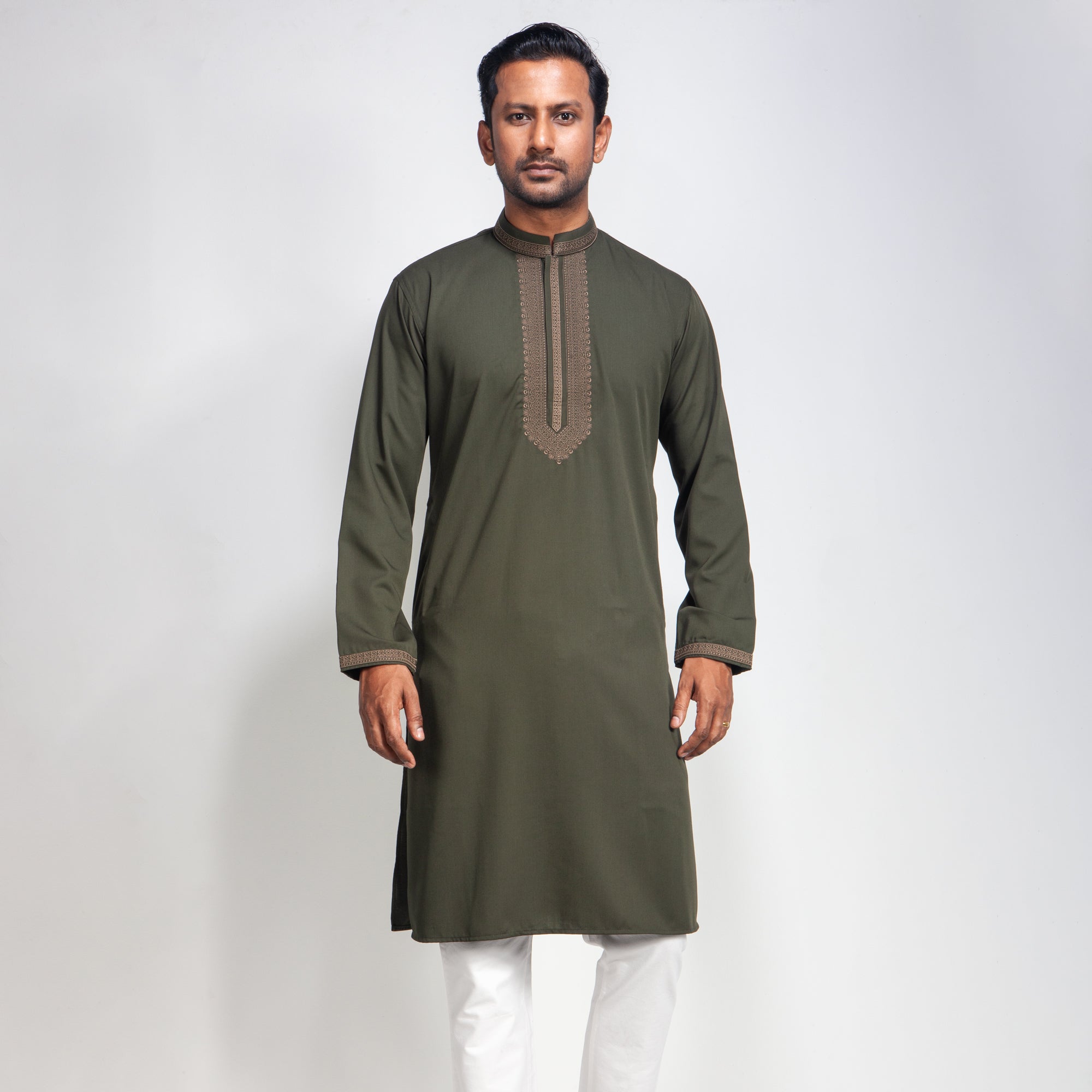 Man wearing an olive green panjabi with white pants on a light gray background