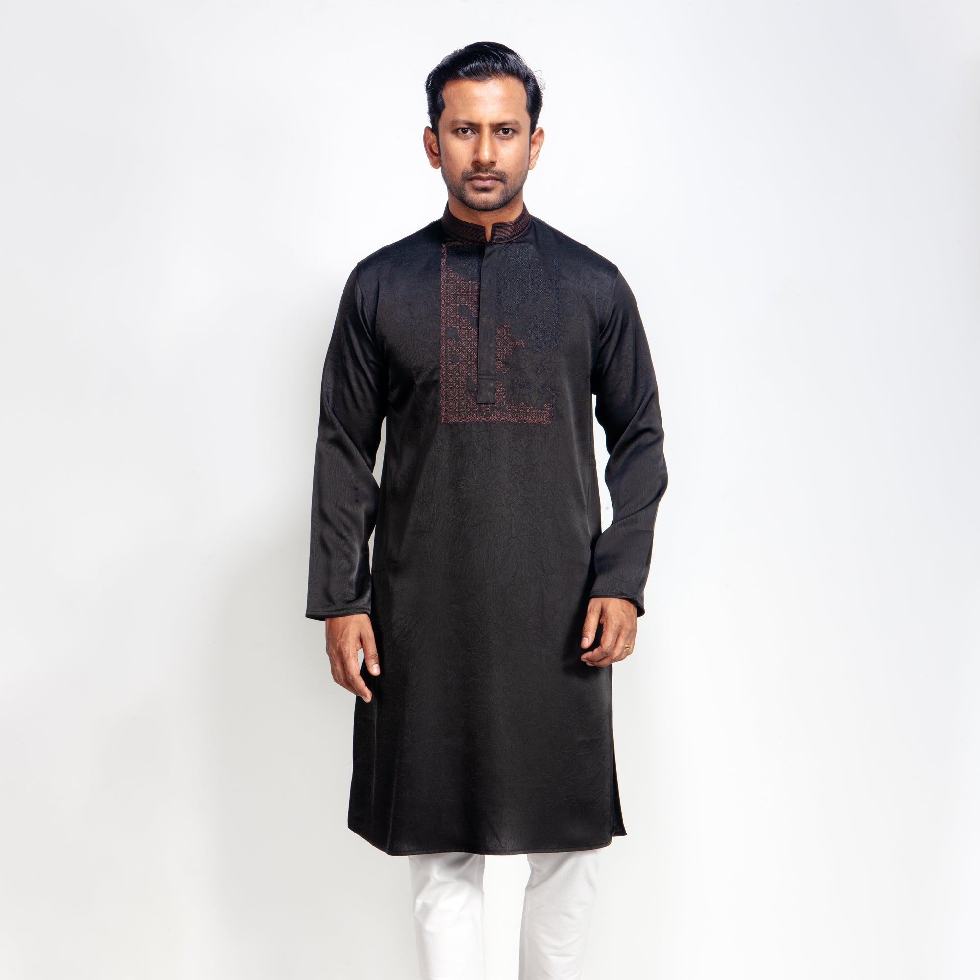 Man wearing a black panjbai with white pants on a white background