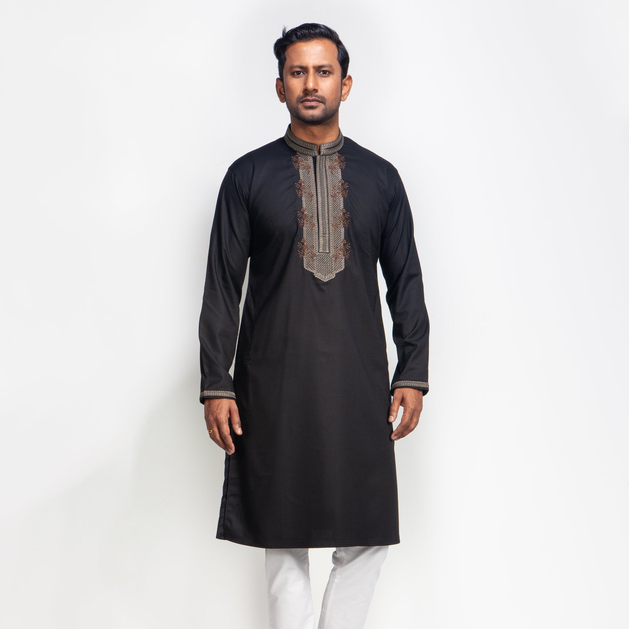 Man wearing a black embroidered panjabi against a white background