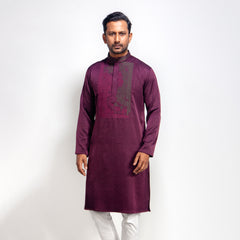 Man wearing a maroon kurta with white pants on a white background