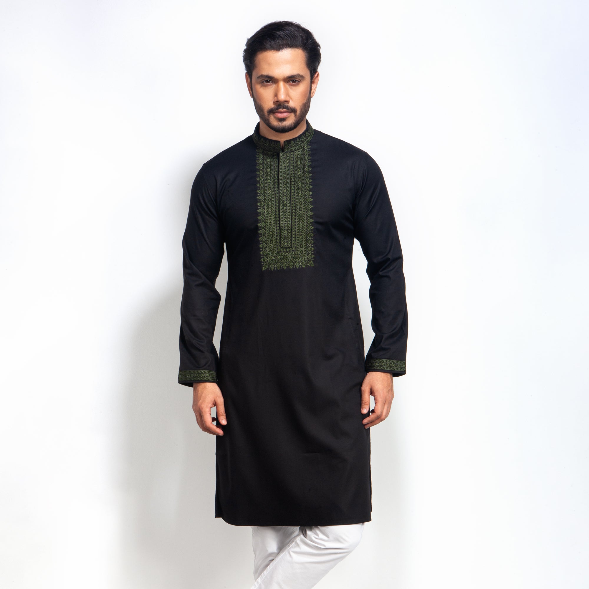 Man wearing a black panjabi with green embroidery on a white background