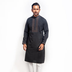 Man wearing a black kurta with white pants on a white background