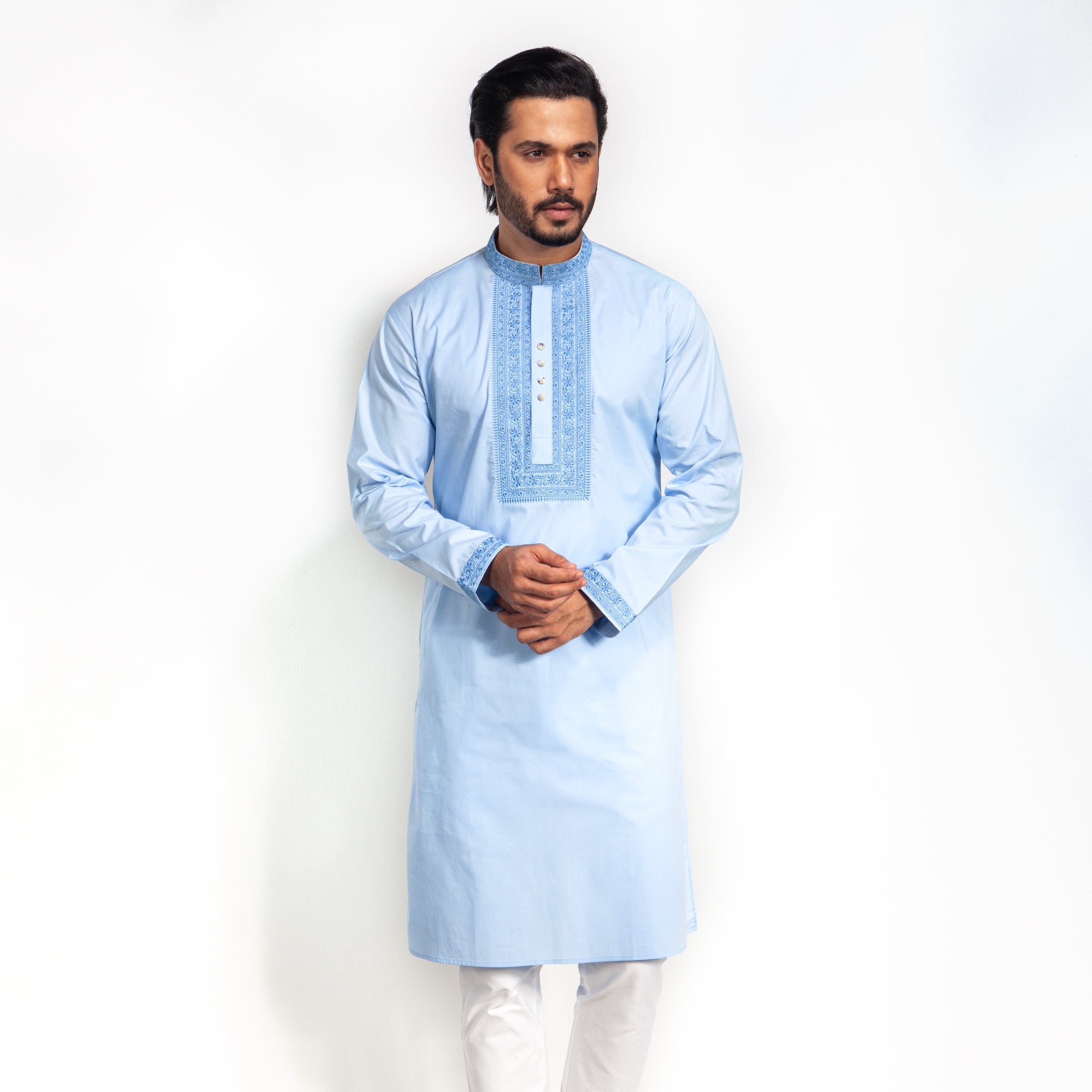 Man wearing a light blue kurta with white pants on a white background