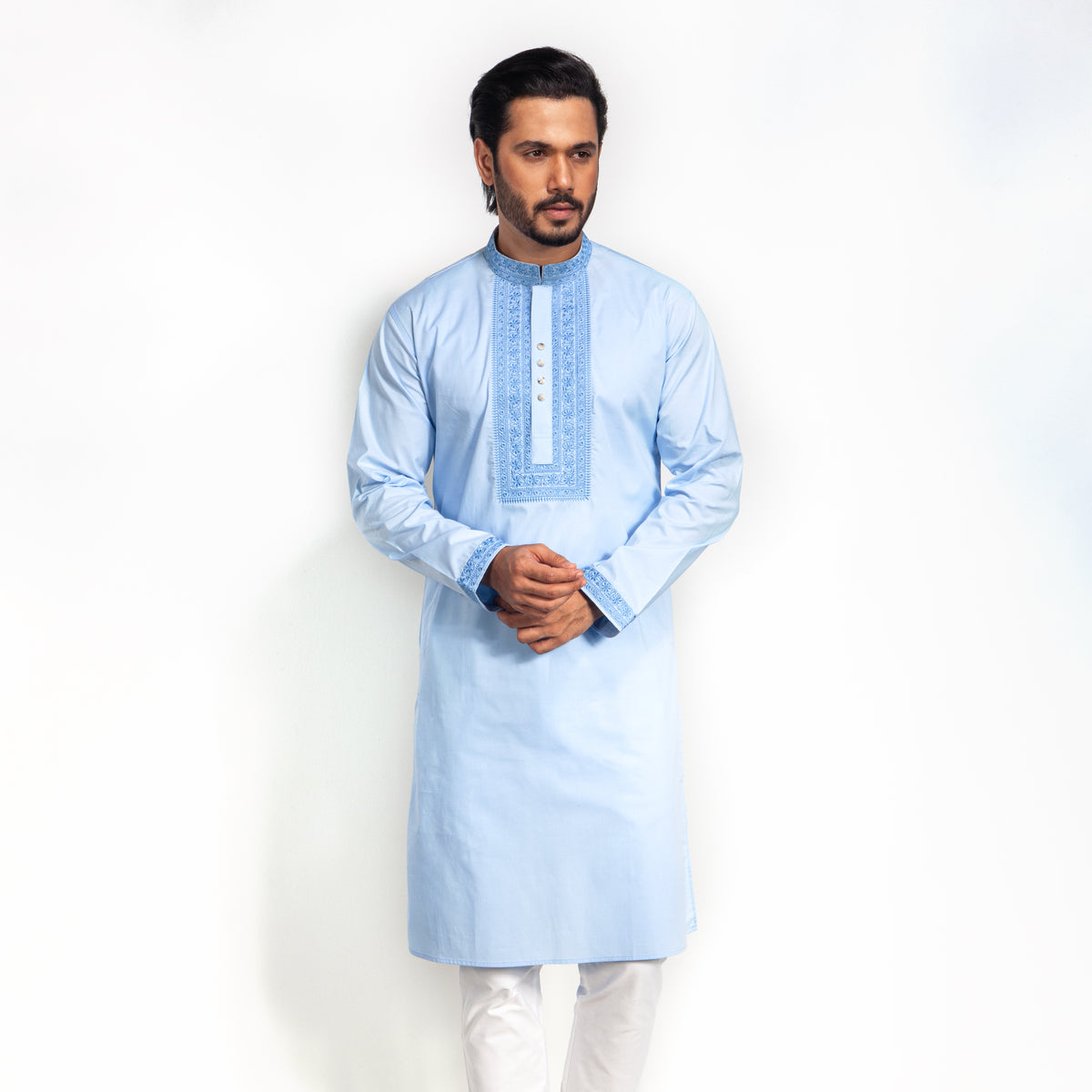 Man wearing a light blue kurta with white pants on a white background