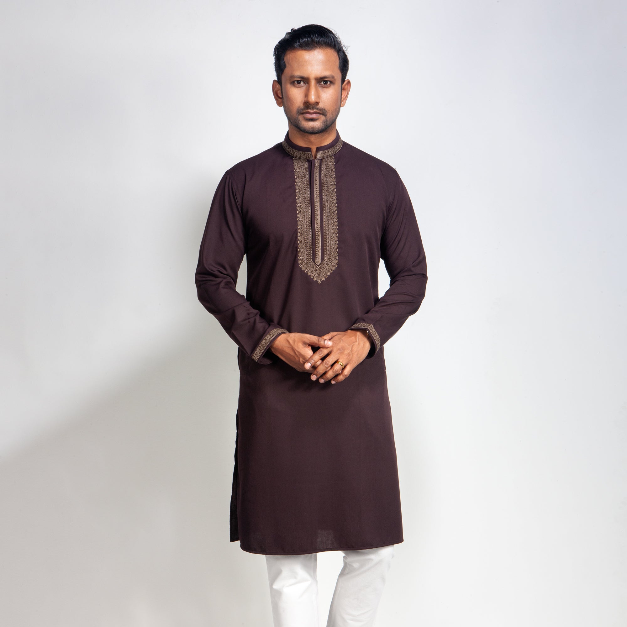 Man wearing a brown Coffee with white pants on a light gray background