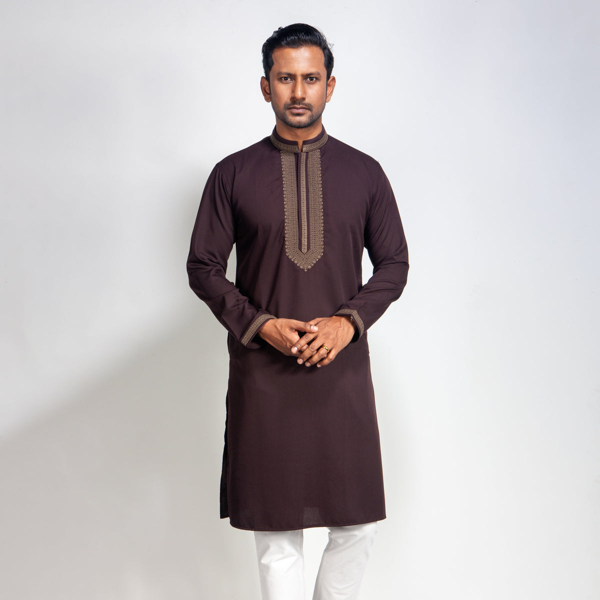 Man wearing a brown Coffee with white pants on a light gray background