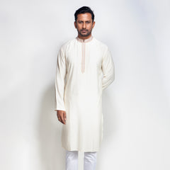 Man wearing a white traditional outfit on a light gray background