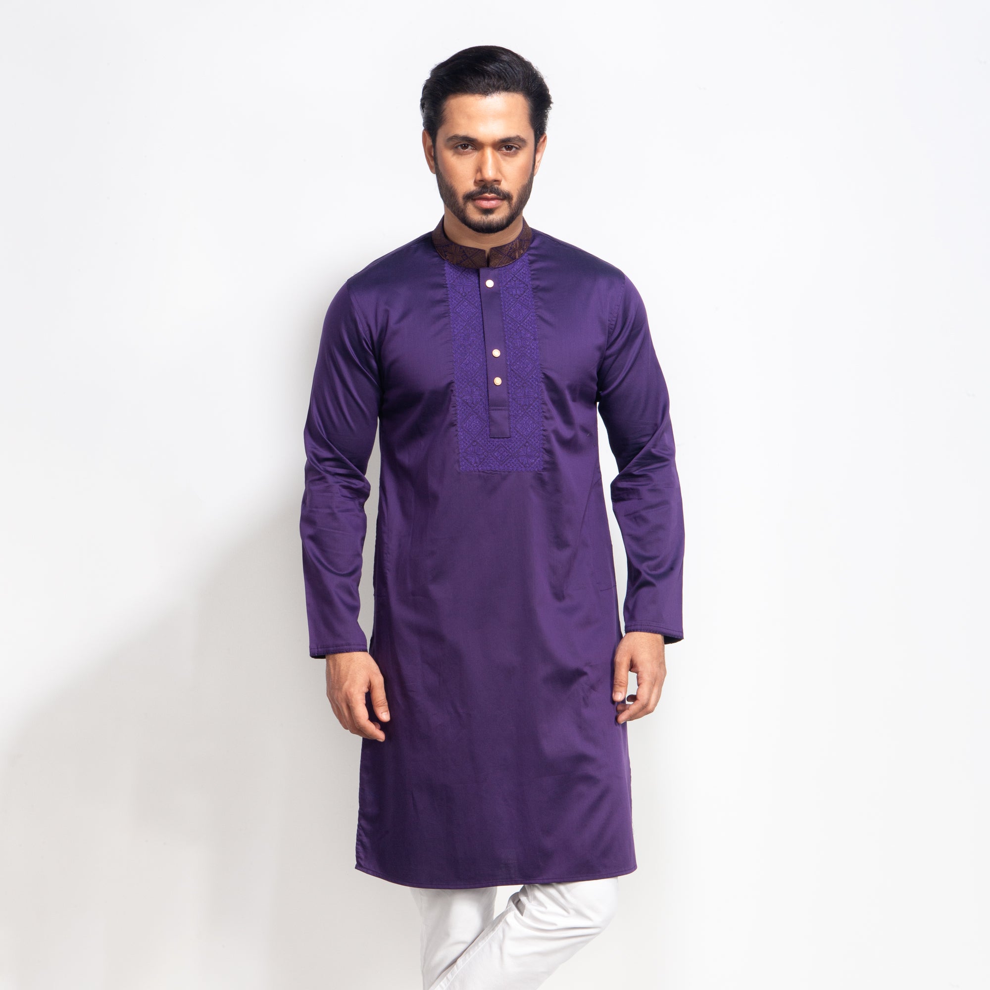 Man wearing a purple kurta against a white background