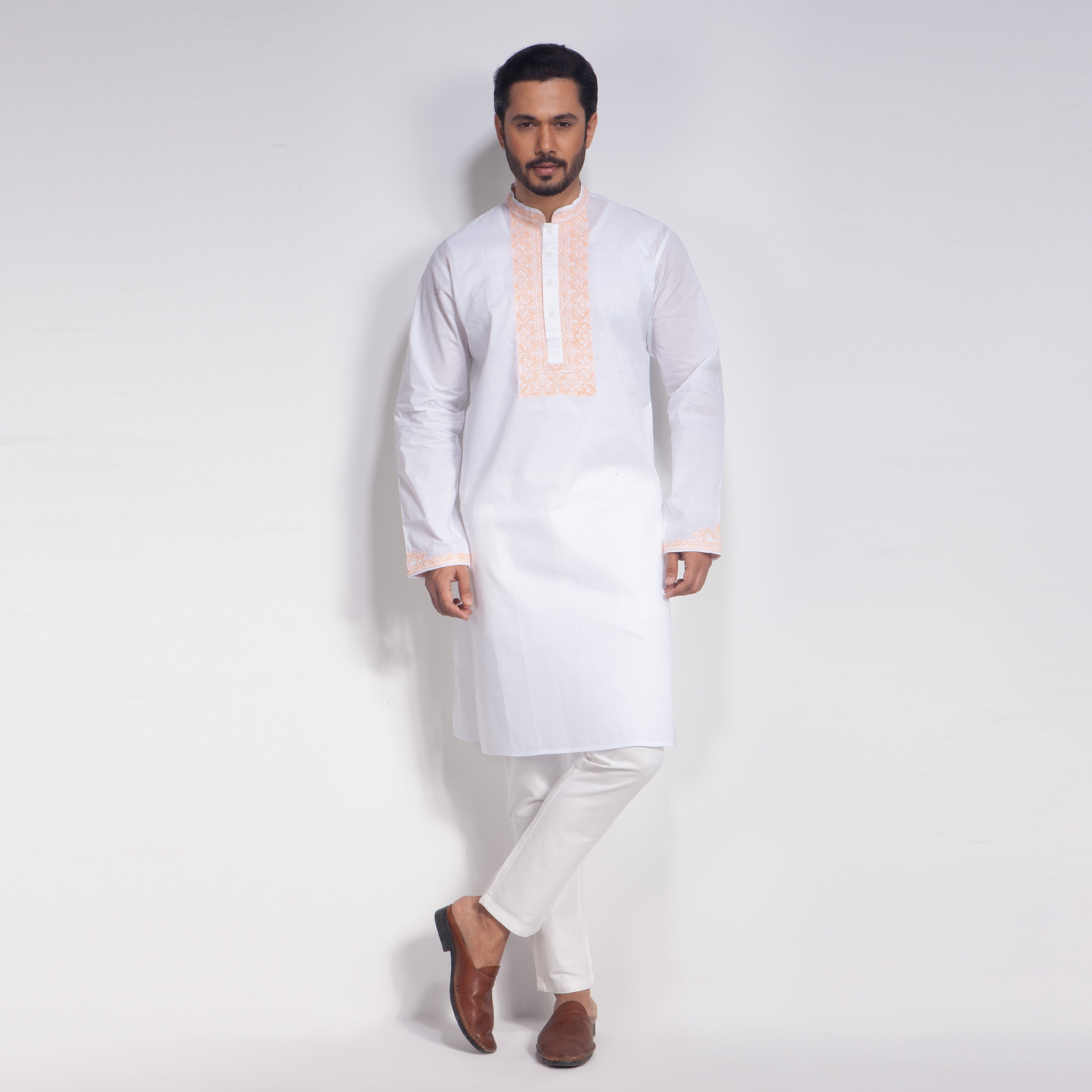 Man wearing a traditional white panjabi with a light pink collar on a white background