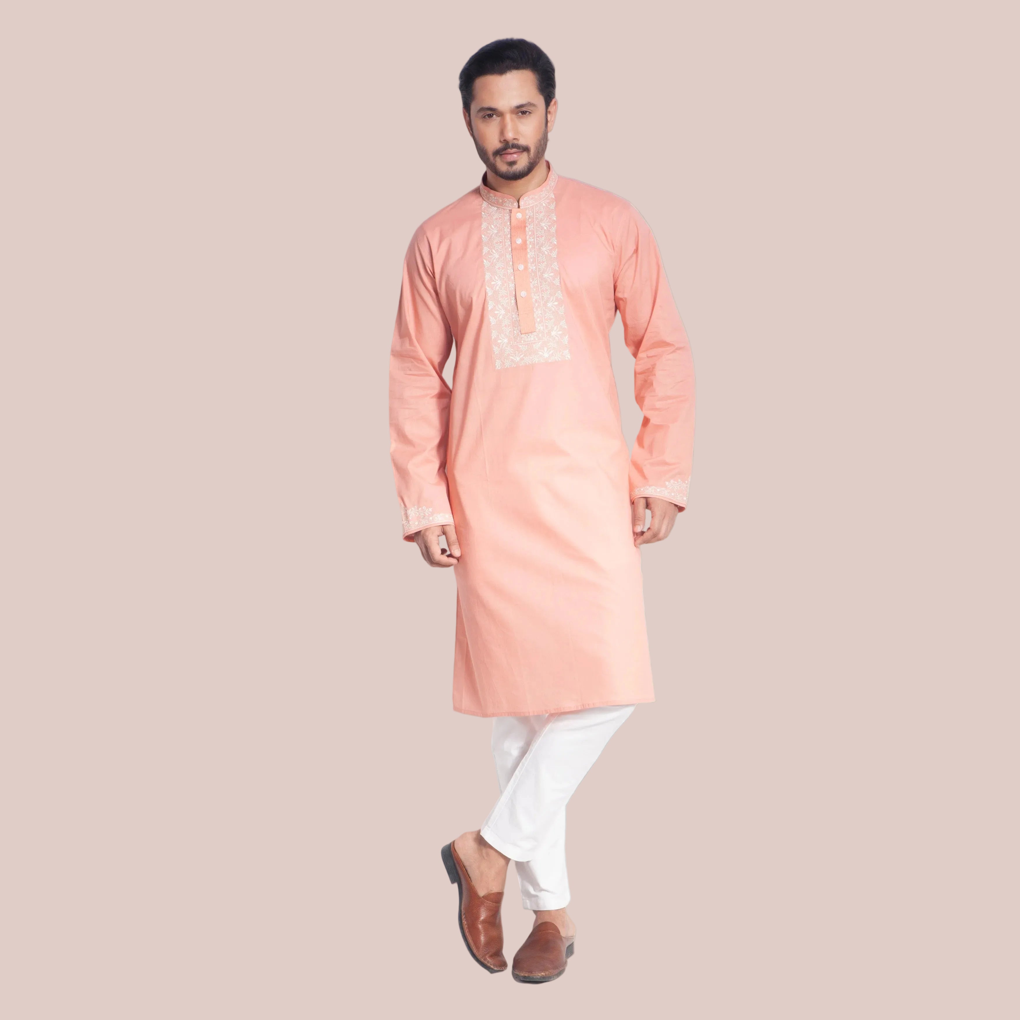 Man wearing a peach kurta with white pants on a white background