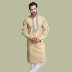 Man wearing a beige kurta with white pants on a light gray background