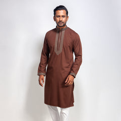Man wearing a coffee color panjabi with white pants on a light gray background