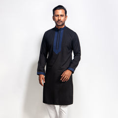 Man wearing a black panjabi with blue embroidery on a white background